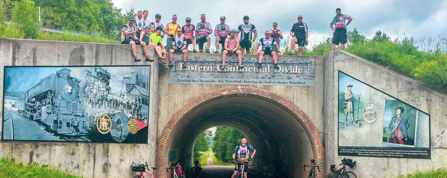 Cyclists on top of Eastern Continental Divide Landmark